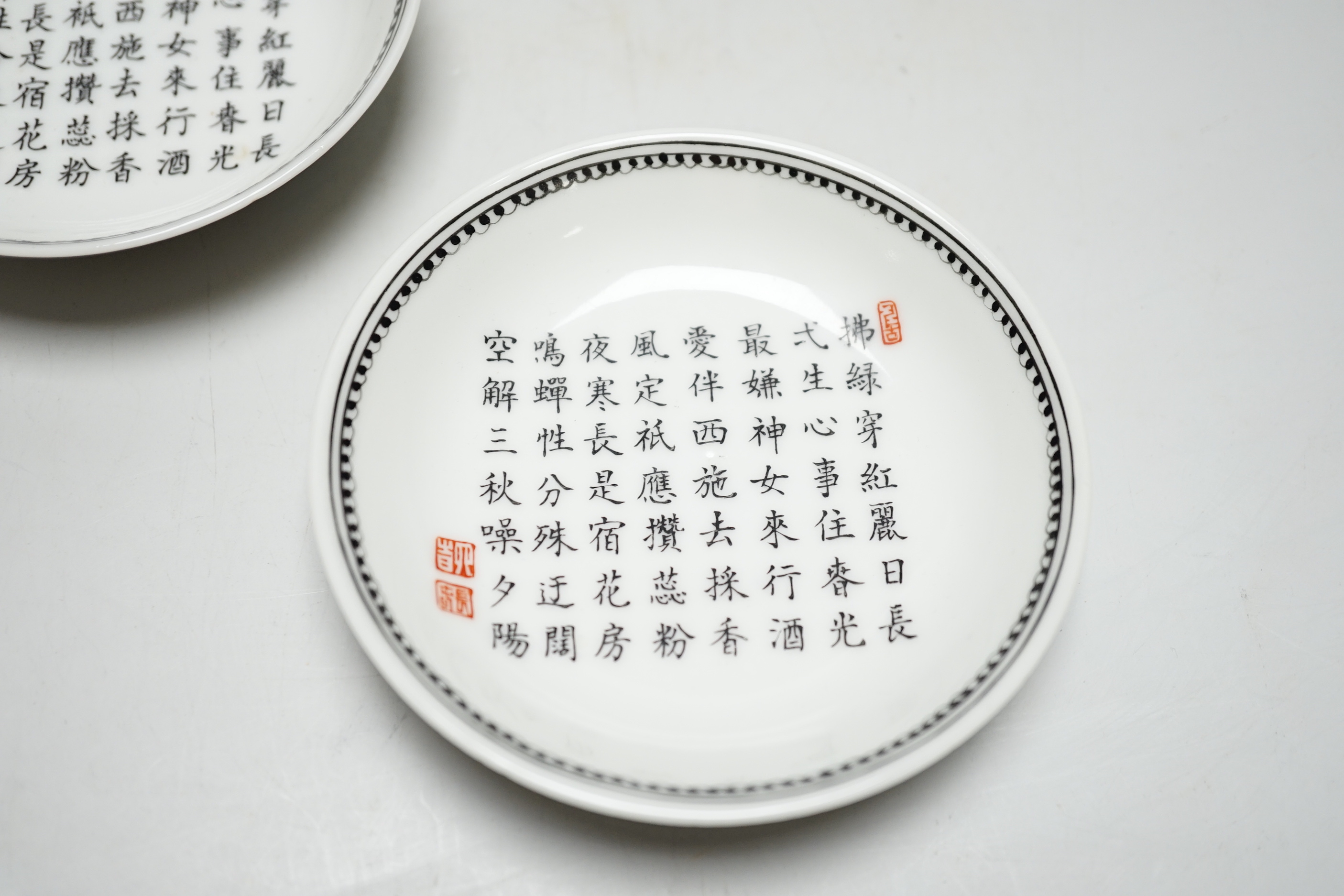 A pair of Chinese calligraphic enamelled porcelain saucers, 9.5cm